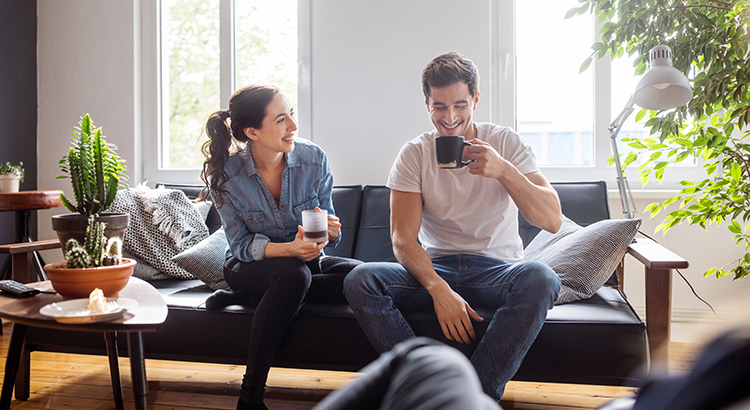 Couple having coffee together in living room
