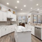 Featuring custom cabinets and backsplash tile, granite counter tops and center island convenient for meal prepping and serving.