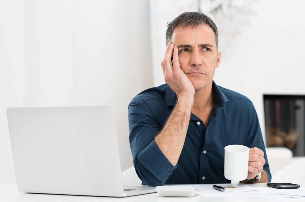 unhappy-man-at-the-desk-picture-id466203577