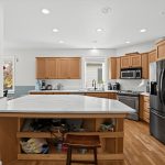 Kitchen island with open shelving and gas range at 16228 SW Cooper Ln Tigard OR