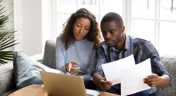 Serious African American couple discussing paper documents