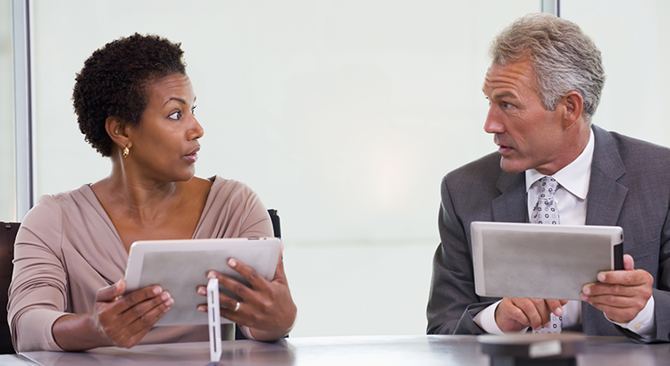 Business people using tablet computers in meeting