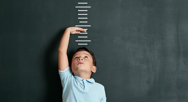 Child measuring his height on wall. He is growing up so fast.